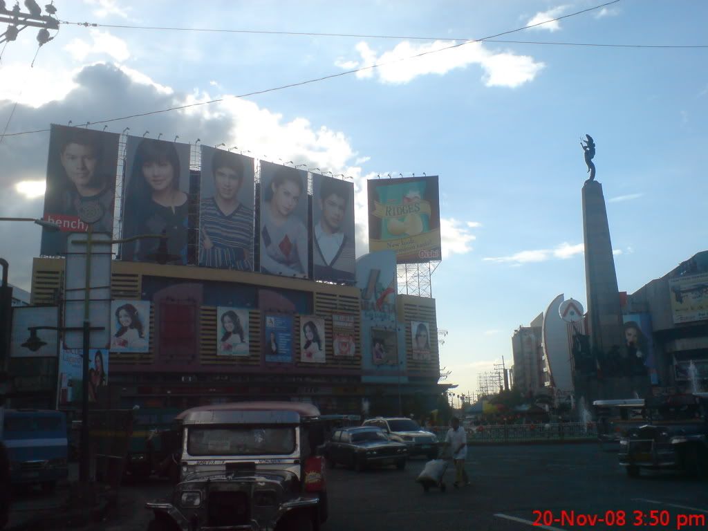 The Bonifacio Monument with Big Billboards at Araneta Square
